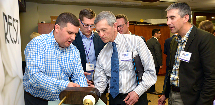 Students show their prototype to Professor Richard Lueptow (center).