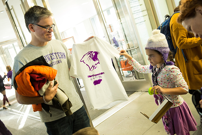 Segal Professor Ken Gentry takes a look at the t-shirt his daughter designed. 