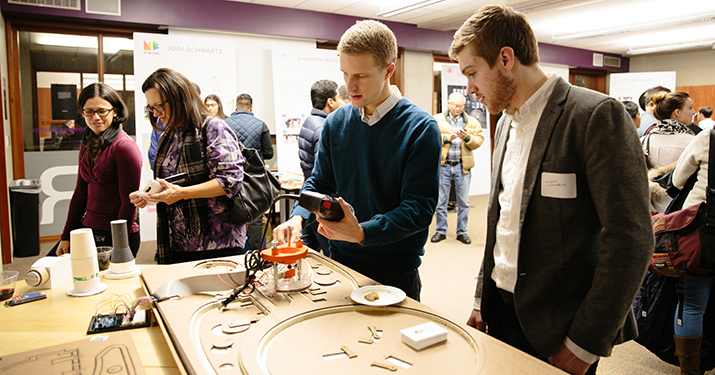 EDI student Brad Gill explains his thesis project to fair attendees.