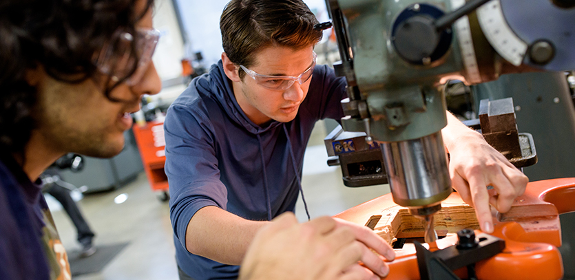 Christopher Bopp (right) assists a fellow student in the Shop.