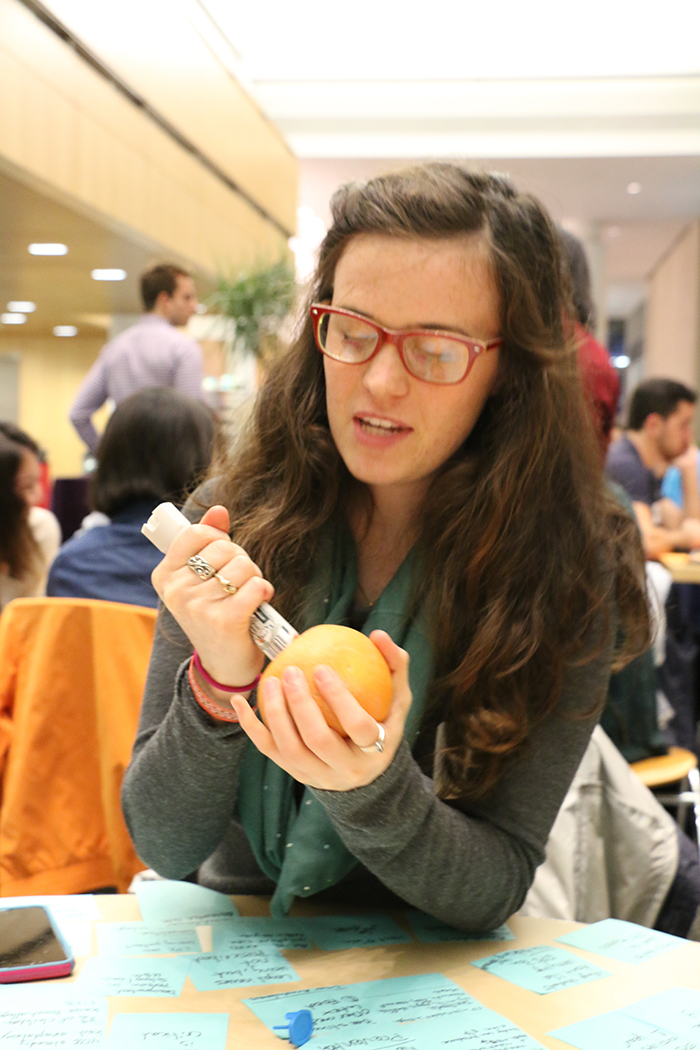 EDI student Aubrey Kraft tries out an auto-injector tester on a grapefruit.