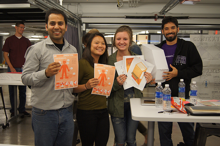 Team “Be Aware. Show You Care” shows off their educational poster prototypes.