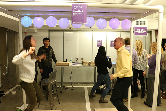 EDI student Phoebe Evans and EDI Director Ed Colgate try out an interactive lantern game designed by Segal students Torey Kocsik, Madeleine Klichowski and Jaehyuk Rhee.