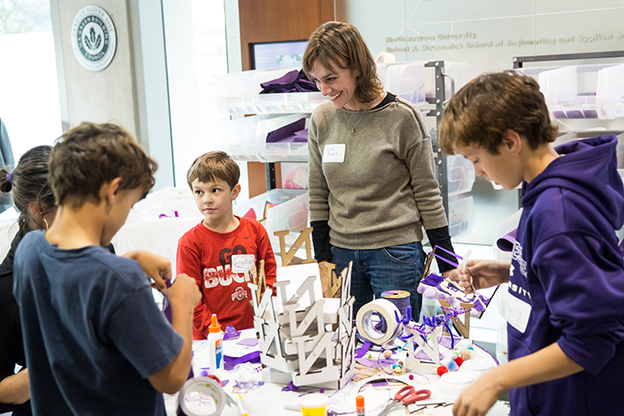 Segal staff member Casey Russel helps her three sons decorate miniature parade floats. 