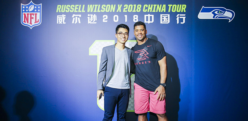 MMM student Richard Xie (left) poses with Russell Wilson, quarterback for the Seattle Seahawks, during his summer internship with the NFL.